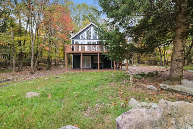 rear view of house featuring a lawn and a wooden deck