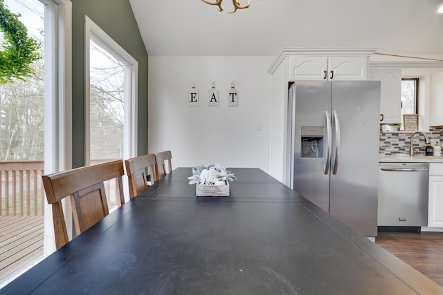 dining area featuring vaulted ceiling, a notable chandelier, and dark wood-style flooring