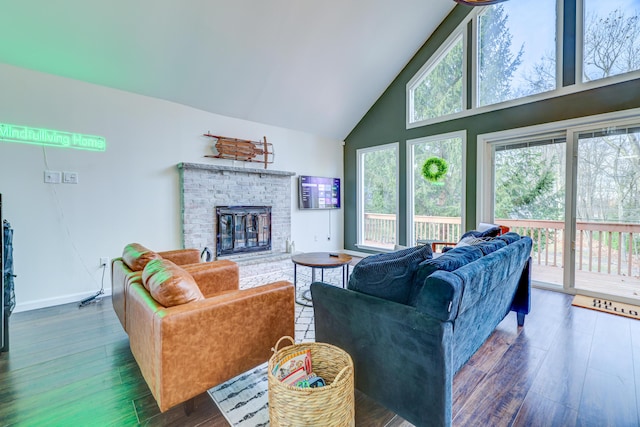 living room featuring a brick fireplace, wood finished floors, baseboards, and high vaulted ceiling