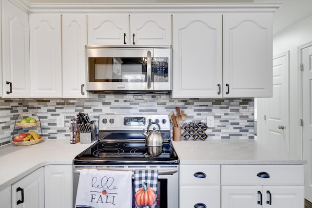 kitchen with stainless steel appliances, white cabinetry, decorative backsplash, and light countertops