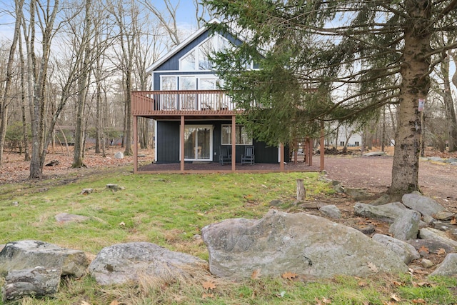 rear view of house with a yard and a deck