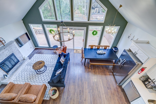 living room featuring high vaulted ceiling, wood finished floors, and a chandelier