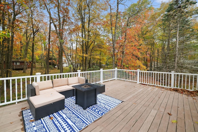 wooden terrace featuring an outdoor living space with a fire pit