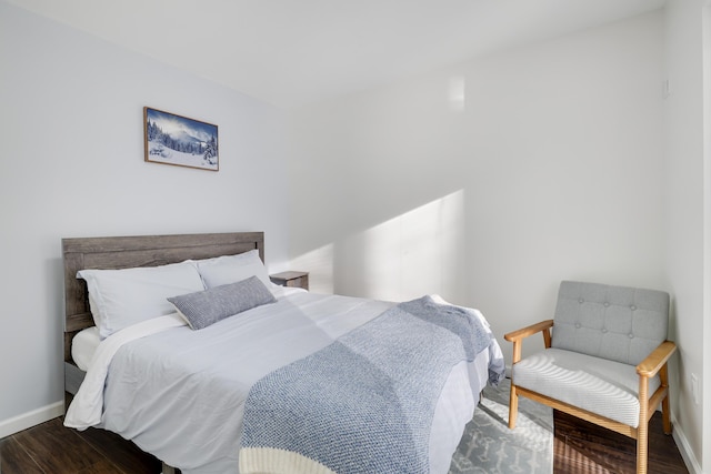 bedroom with baseboards and wood finished floors