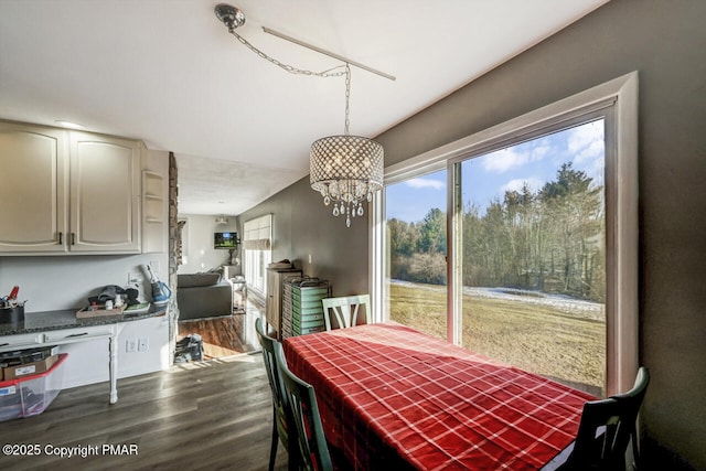 dining space featuring hardwood / wood-style flooring and an inviting chandelier