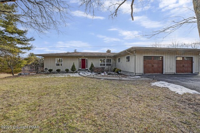 ranch-style house featuring a garage and a front yard