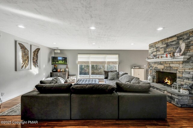 living room featuring a textured ceiling, a fireplace, and dark hardwood / wood-style flooring