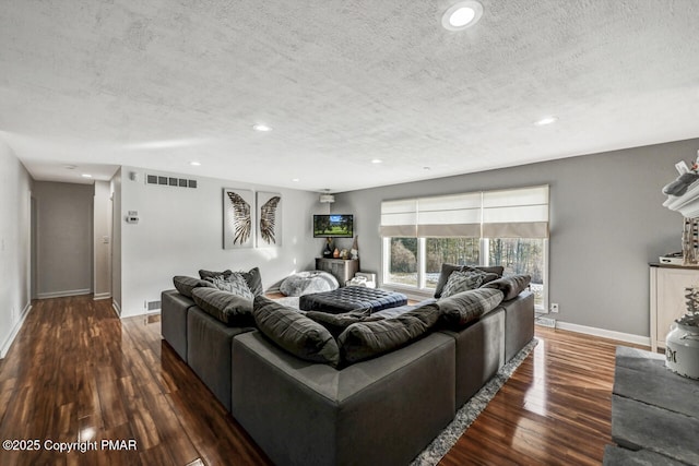 living room with dark hardwood / wood-style floors and a textured ceiling