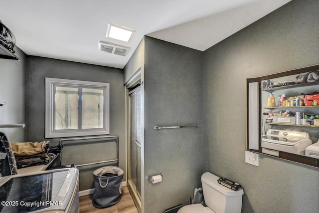 bathroom featuring hardwood / wood-style flooring and toilet