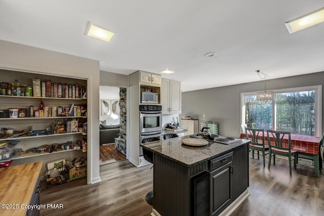 kitchen with wood counters, decorative light fixtures, dark hardwood / wood-style flooring, and double oven