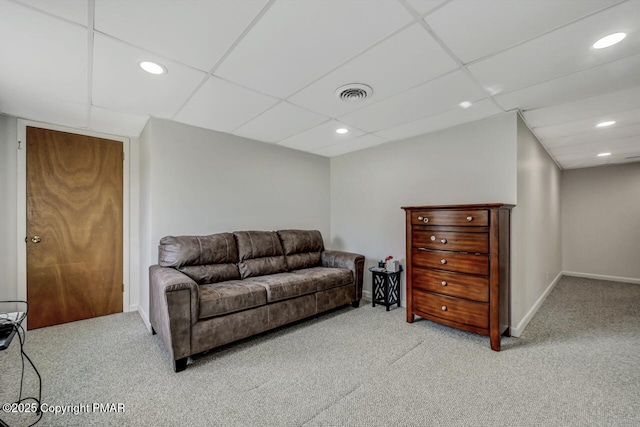 carpeted living room with a paneled ceiling