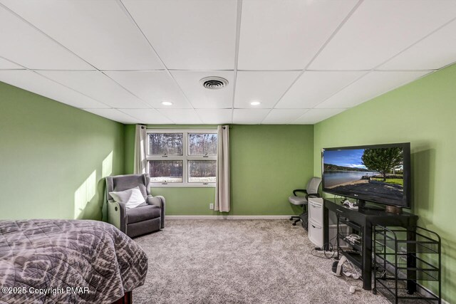 bedroom with a paneled ceiling and light colored carpet