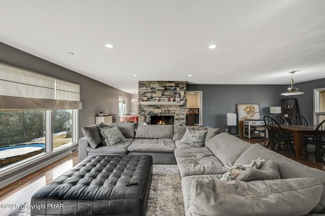 living room featuring a stone fireplace and hardwood / wood-style floors