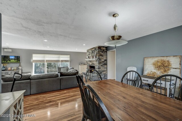 dining area featuring a fireplace and light wood-type flooring