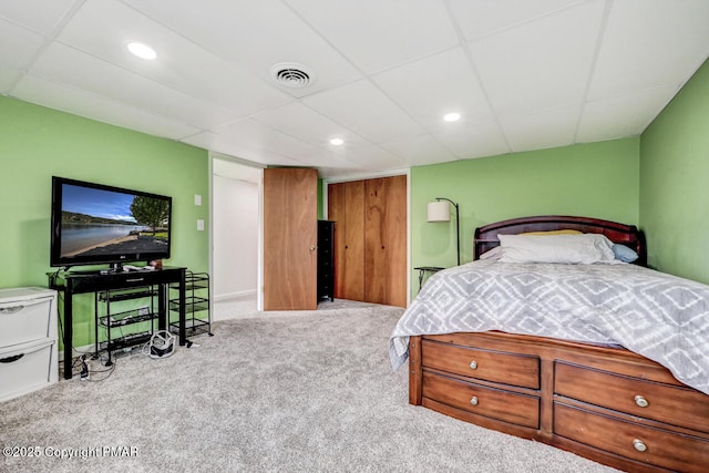 carpeted bedroom featuring a drop ceiling