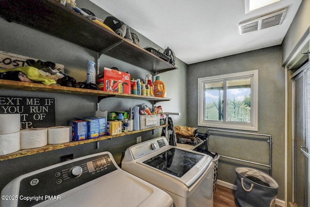 clothes washing area with hardwood / wood-style flooring and washer and clothes dryer