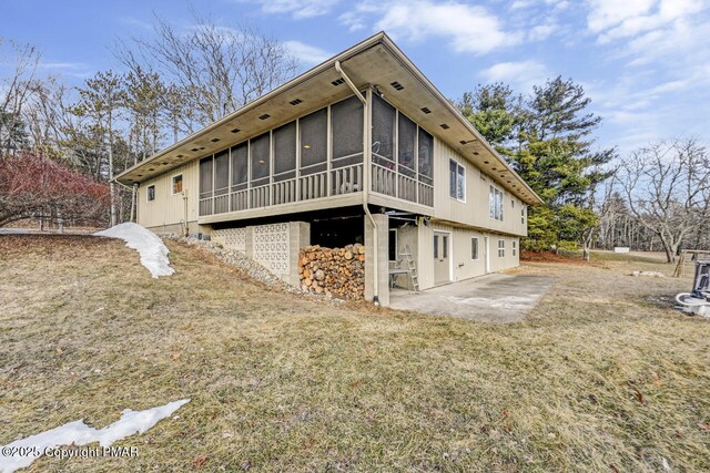 back of property featuring a patio, a sunroom, and a yard