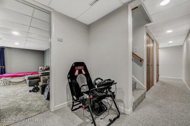 exercise area with carpet floors and a paneled ceiling