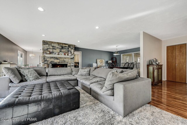 living room featuring hardwood / wood-style flooring, a fireplace, and an inviting chandelier