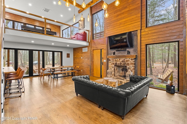 living room featuring visible vents, wooden walls, and wood finished floors