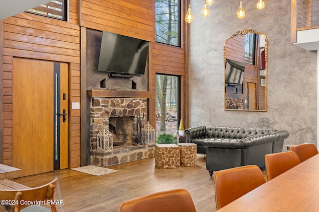 living room featuring wood finished floors, a healthy amount of sunlight, and a towering ceiling