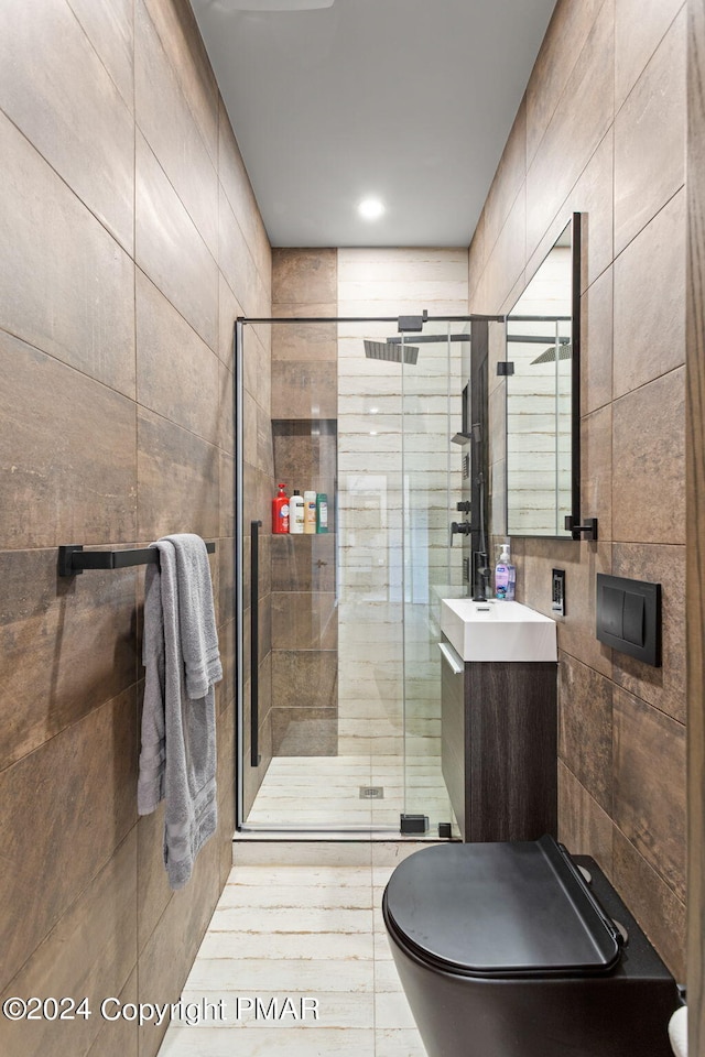 full bathroom with tile walls, a stall shower, and vanity