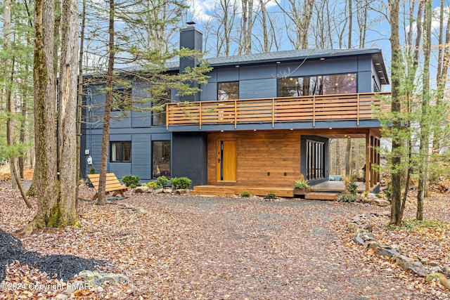 contemporary house featuring a deck and a chimney