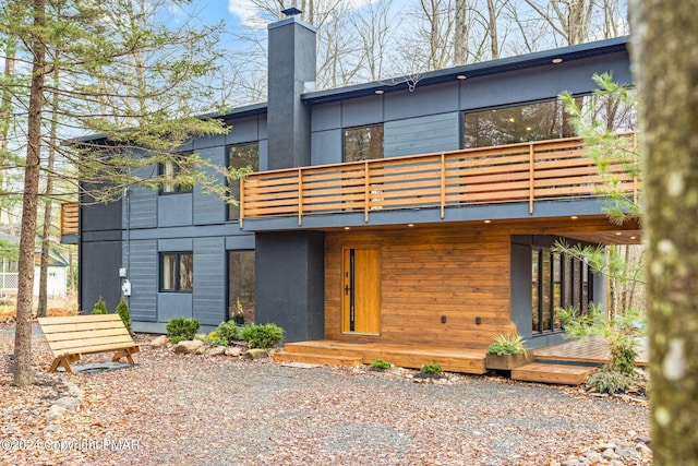 back of house featuring a chimney