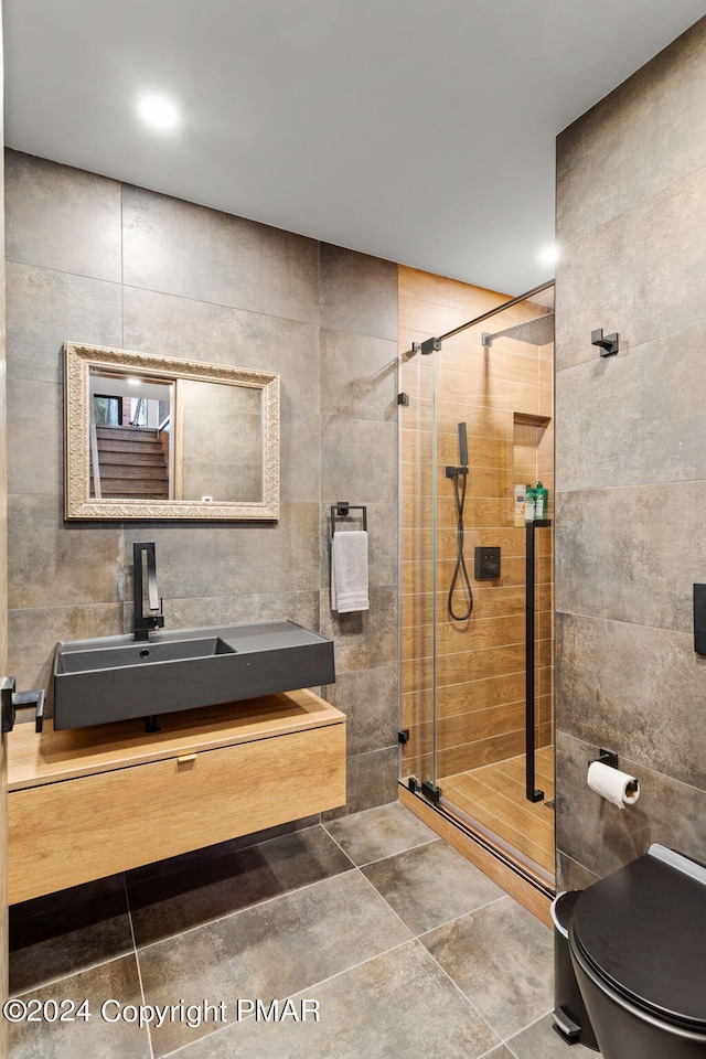 full bath featuring toilet, a stall shower, tile walls, and vanity