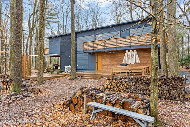 rear view of property featuring a wooden deck