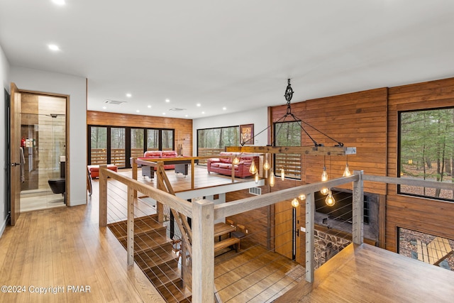 dining space with visible vents, recessed lighting, wooden walls, and wood finished floors