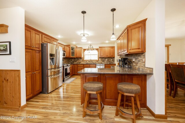 1212 Acacia Dr, Hawley, PA 18428 - kitchen with a sink, stainless steel appliances, brown cabinets, and a peninsula