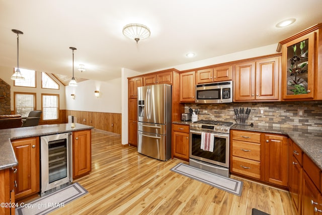 1212 Acacia Dr, Hawley, PA 18428 - kitchen featuring light wood-type flooring, a wainscoted wall, beverage cooler, appliances with stainless steel finishes, and brown cabinetry