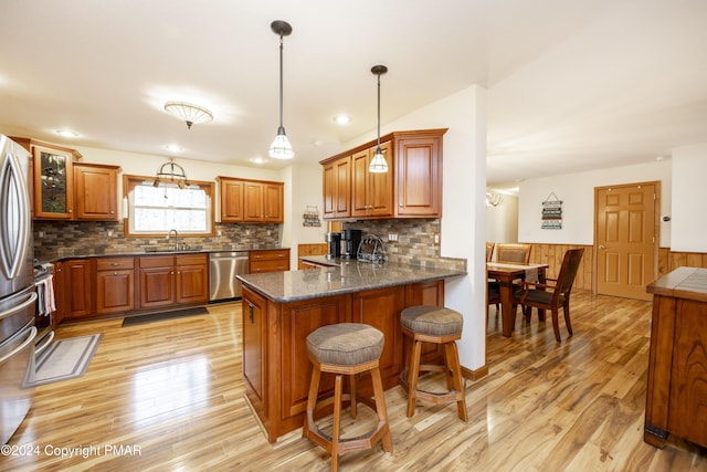 1212 Acacia Dr, Hawley, PA 18428 - kitchen with brown cabinetry, a peninsula, light wood-style flooring, a sink, and dishwasher