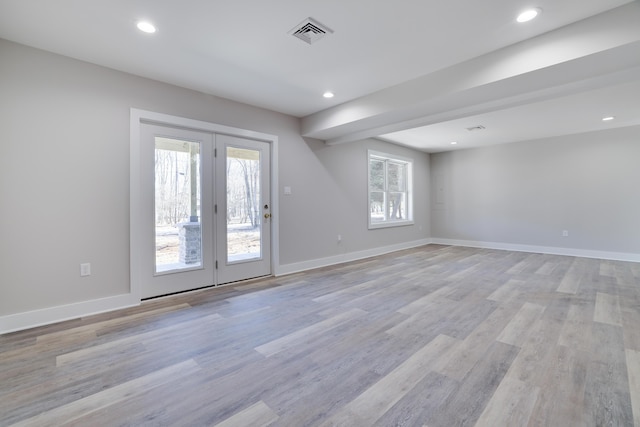 empty room with light wood-style flooring, baseboards, and visible vents