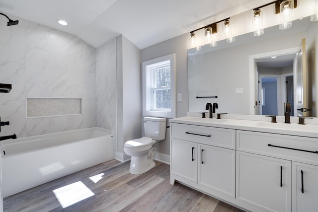 full bath with wood finished floors, a bathing tub, toilet, and a sink