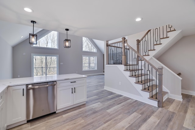 interior space featuring dishwasher, white cabinets, light stone counters, and light wood-style flooring