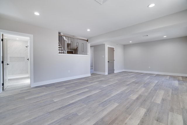 unfurnished living room with stairs, recessed lighting, light wood-style floors, and baseboards