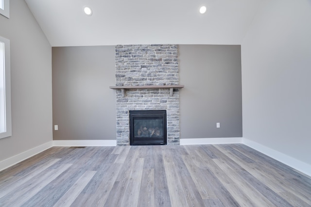 unfurnished living room featuring a fireplace, wood finished floors, and baseboards