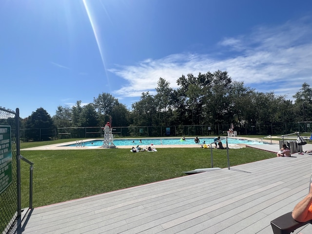 pool featuring a lawn and fence