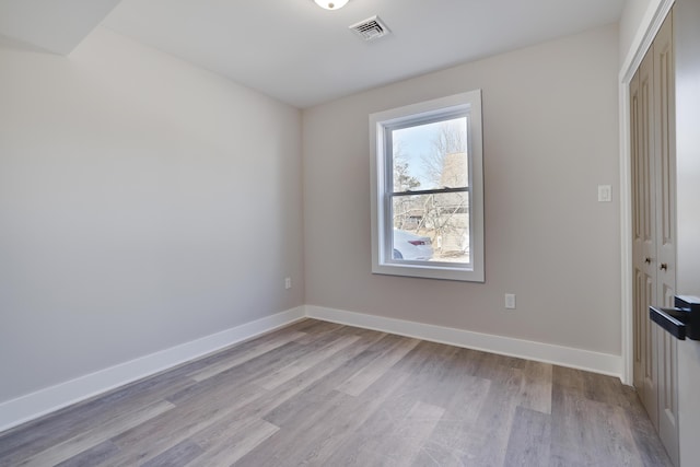 unfurnished room featuring visible vents, baseboards, and wood finished floors