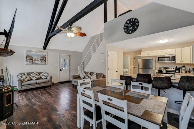 dining room featuring high vaulted ceiling, dark hardwood / wood-style flooring, a baseboard radiator, beamed ceiling, and a wood stove