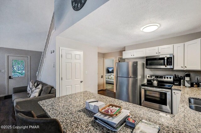 bathroom featuring vanity, a textured ceiling, and toilet