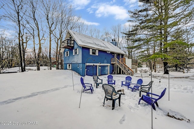 snow covered house featuring a garage