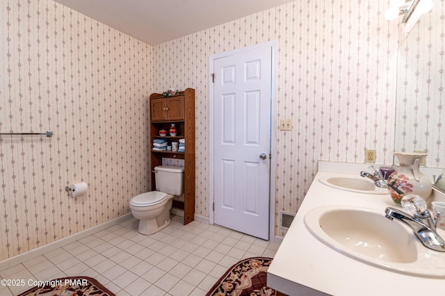 bathroom with tile patterned floors, a sink, and wallpapered walls