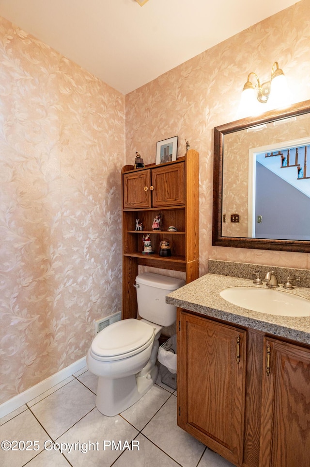 half bathroom with wallpapered walls, visible vents, toilet, tile patterned floors, and vanity