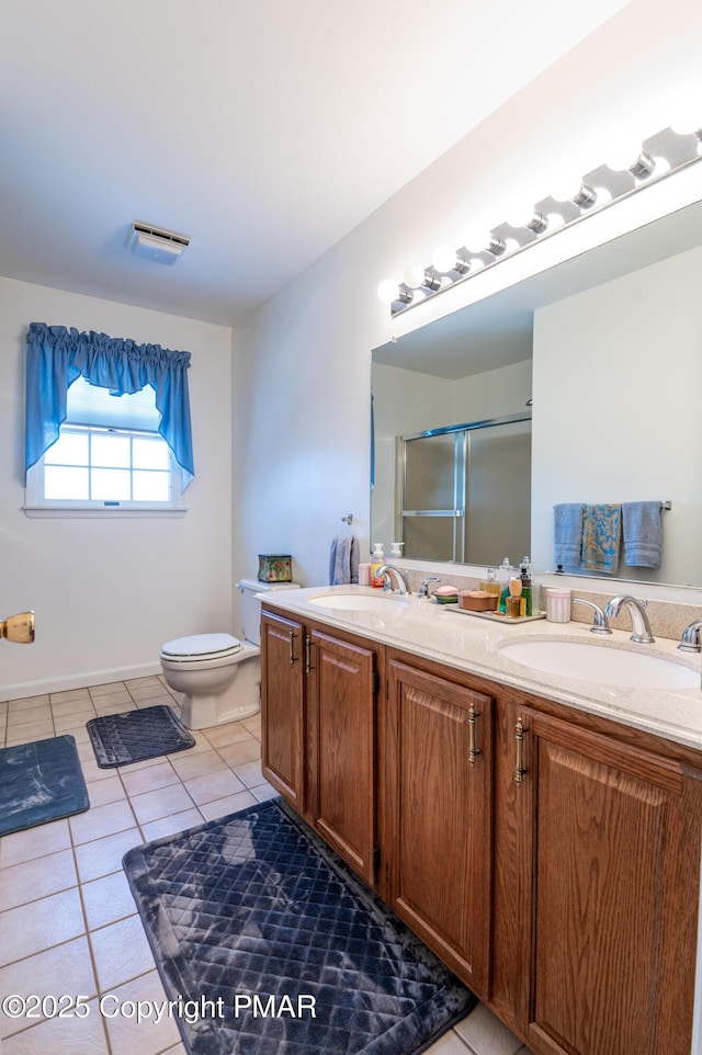 bathroom with toilet, a sink, tile patterned floors, double vanity, and an enclosed shower