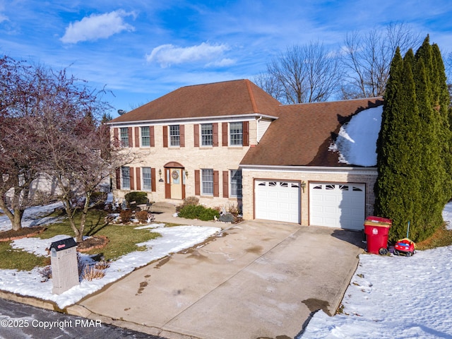 colonial house with an attached garage, a shingled roof, and concrete driveway