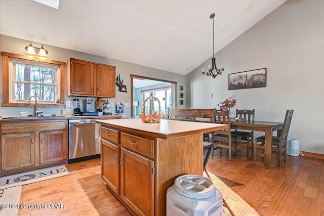 kitchen featuring dishwasher, light wood-type flooring, a sink, and brown cabinets