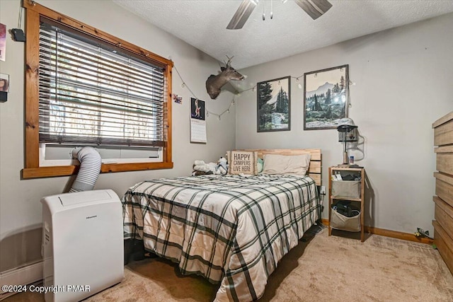 bedroom with a ceiling fan, carpet, a textured ceiling, and baseboards